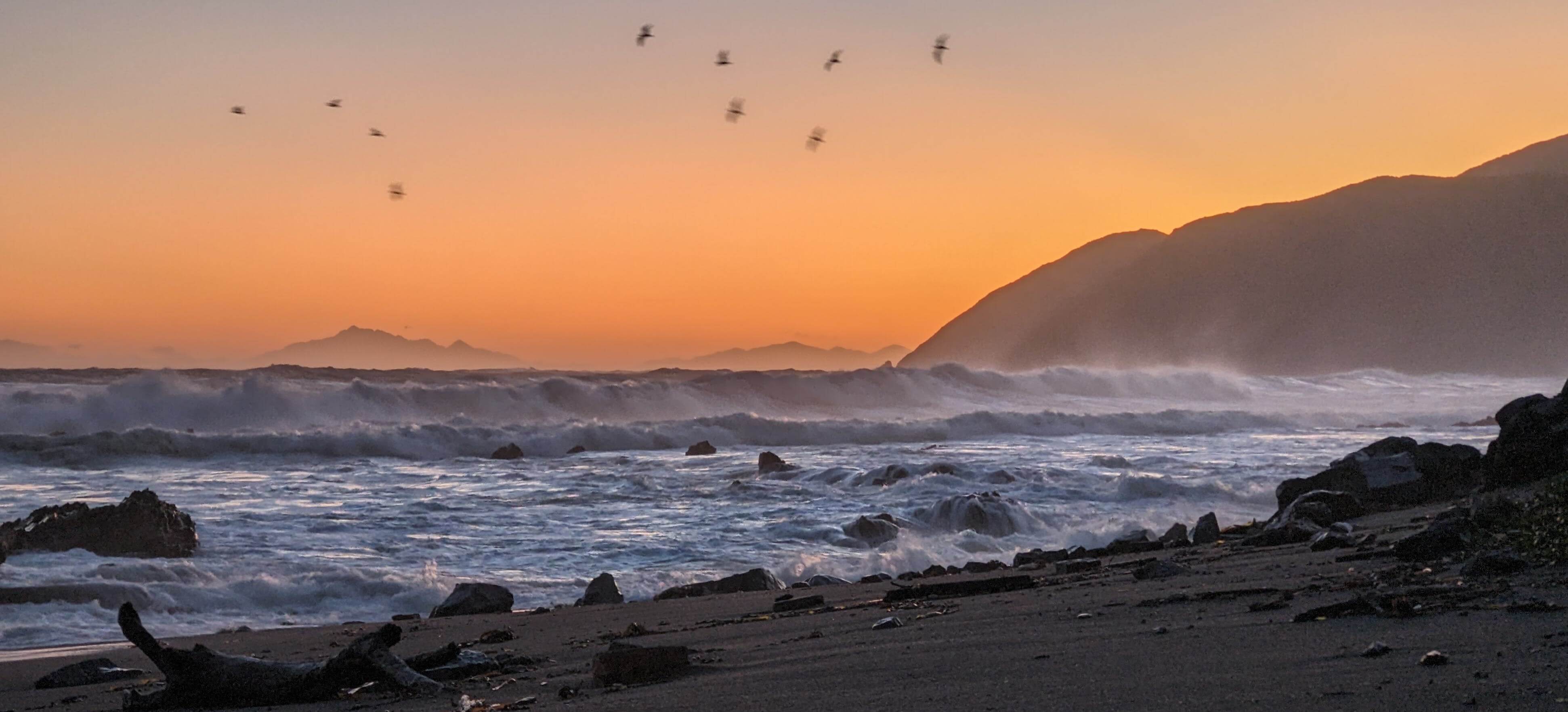 Surf and sunset at Ōwhiro Bay, Aoteroa New Zealand